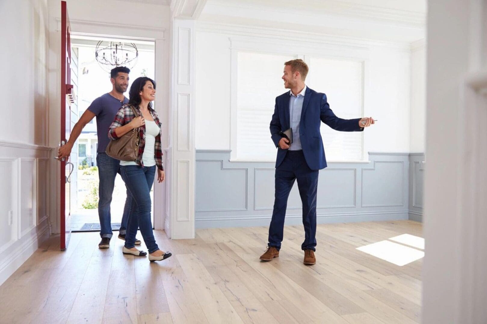 A man and two women in a room with a door open.